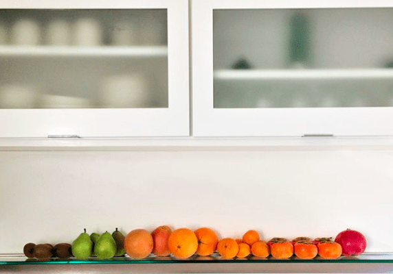 fruit arranged in a rainbow on a shelf