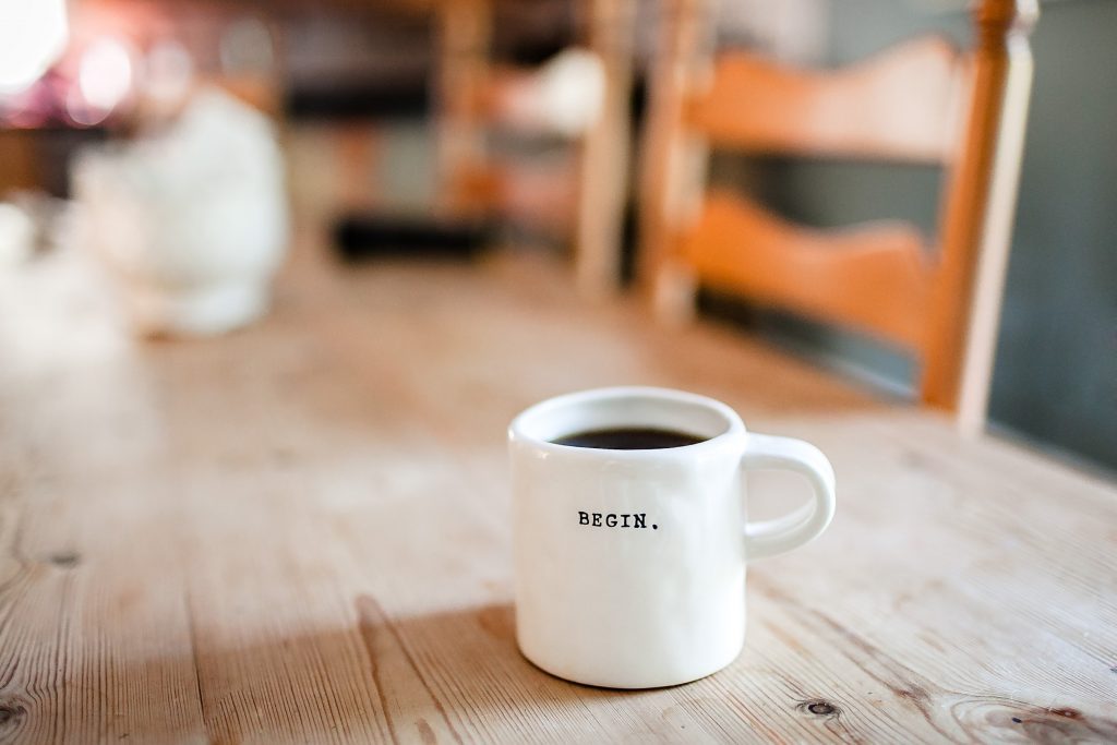 white coffee cup with writing on a wooden table
