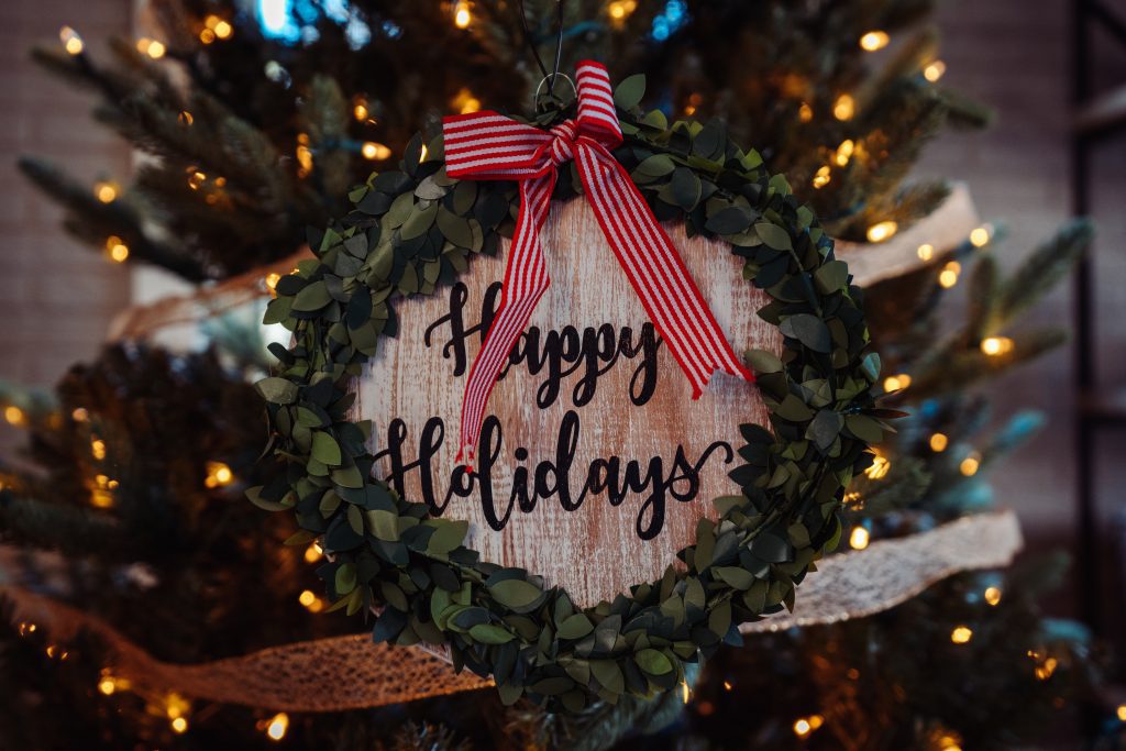 a wreath with the words happy holidays in the middle