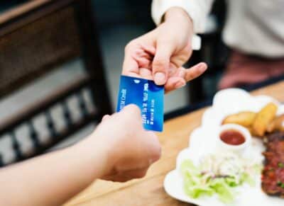 one person handing another person a credit card